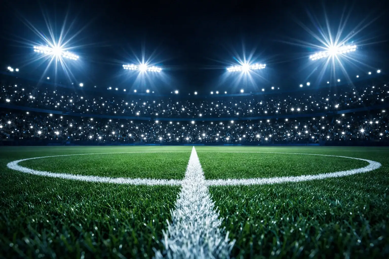 Campo di calcio illuminato con il cerchio di centrocampo in primo piano durante una notte di Champions League